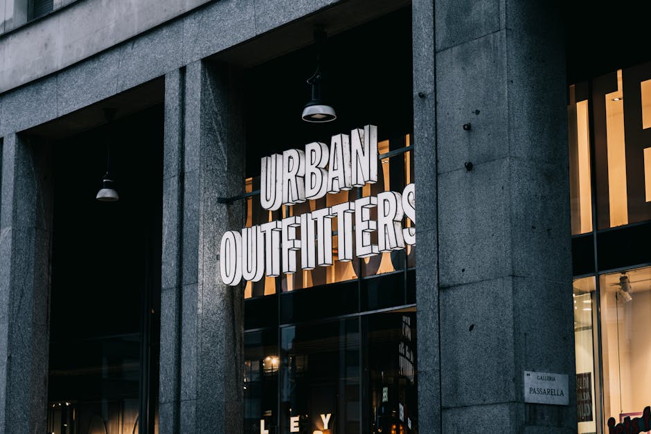 Urban Outfitters store entrance with illuminated signage in a city environment.